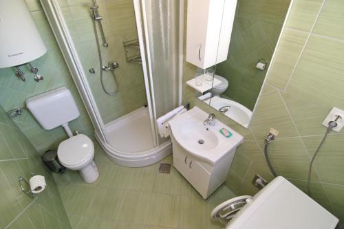 ein Badezimmer mit Waschbecken, Toilette und Dusche in der Unterkunft Holiday House Palma in Dobrinj
