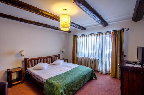 a bedroom with a bed and a large window at Resort Cheile Gradistei Moieciu in Moieciu de Sus
