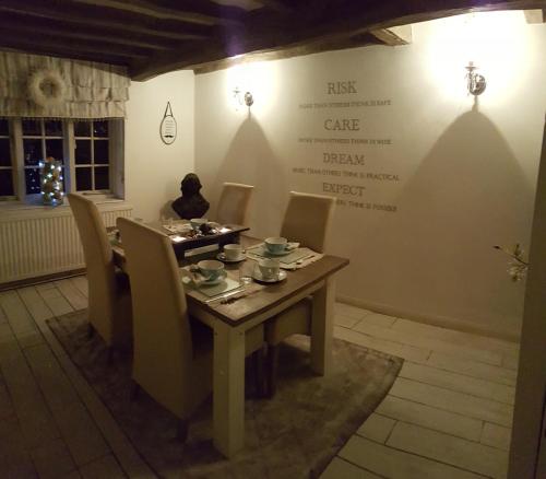 une salle à manger avec une table et des chaises et un mur avec un menu dans l'établissement Tudor Farm B&B, à Elston