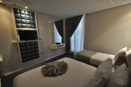 a hotel room with two beds and a couch at Montana Al Azizia Hotel in Makkah