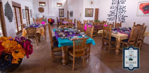 a dining room with tables and chairs and flowers at Casa Benavides Inn in Taos