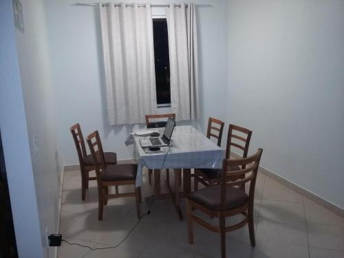 a dining room with a table with a laptop on it at Alfon Hotel in Itabira