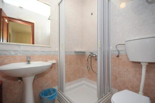 a bathroom with a shower and a sink and a toilet at Apartments Balic in Sveti Stefan