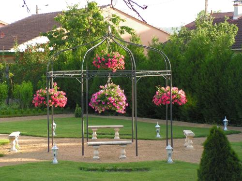 Côté Jardin في Commercy: حديقة بها طاولة نزهة عليها زهور