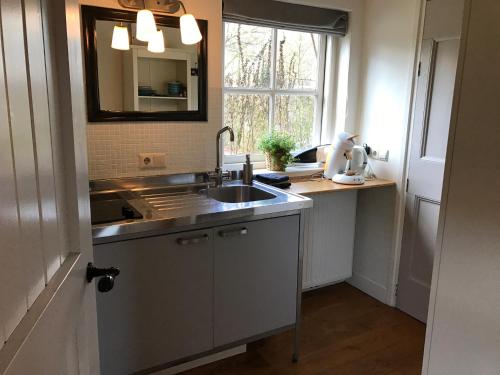 a kitchen with a sink and a window at Erve Ziegers in Vilsteren