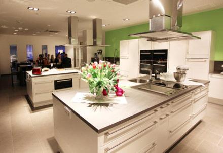 a large kitchen with green walls and a counter with flowers on it at Hotel Soho in Landau in der Pfalz