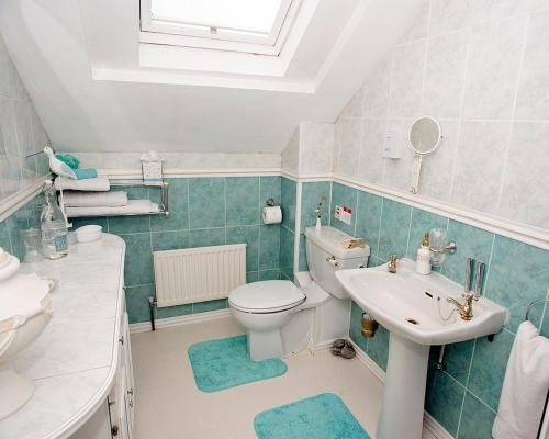 a bathroom with a white toilet and a sink at Craig Park House in Airdrie