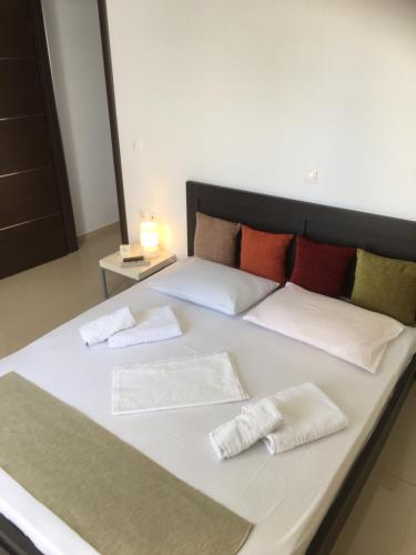 a large white bed with two pillows on it at Boussetil Apartment in Tinos