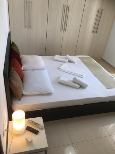a bed with white pillows and towels on it at Boussetil Apartment in Tinos