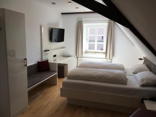 ein Schlafzimmer mit einem Bett, einem Fenster und einem Sofa in der Unterkunft Gasthaus Rebstock Egringen in Efringen-Kirchen