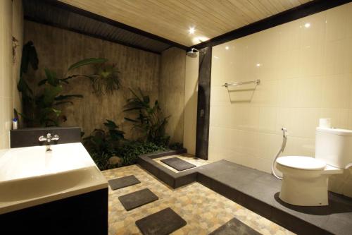a bathroom with a sink and a toilet and plants at The Forest Villa Ubud in Ubud
