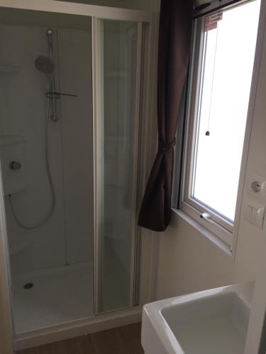 La salle de bains est pourvue d'une douche, d'un lavabo et d'une fenêtre. dans l'établissement Albaluce Village Viverone, à Viverone