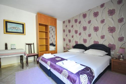 a bedroom with a large bed and a piano at Apartments Balic in Sveti Stefan