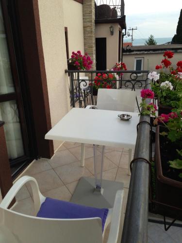 a white table and chairs on a balcony with flowers at Holiday Home Barska Vila in Bar