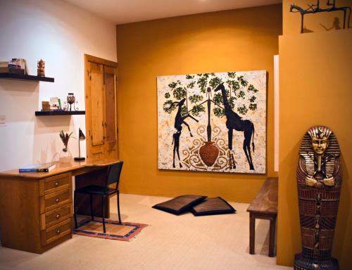 a room with a desk and a painting of giraffes at Three Cities Apartments in Cospicua