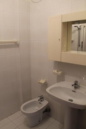 een witte badkamer met een wastafel en een toilet bij Ruffelli in Grado