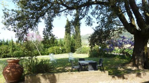 a table and chairs under a tree in a garden at Al Vecchio Leccio in Pistoia