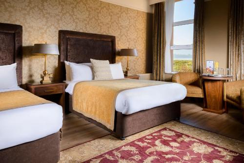 um quarto de hotel com duas camas e uma janela em The Lake Hotel em Killarney