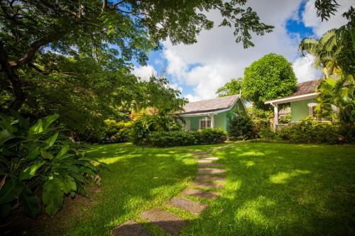 a green house with a grass yard at East Winds St. Lucia- All Inclusive in Gros Islet