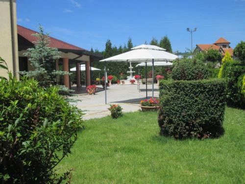 a garden with an umbrella and a building at Hotel Valeria in Simbario