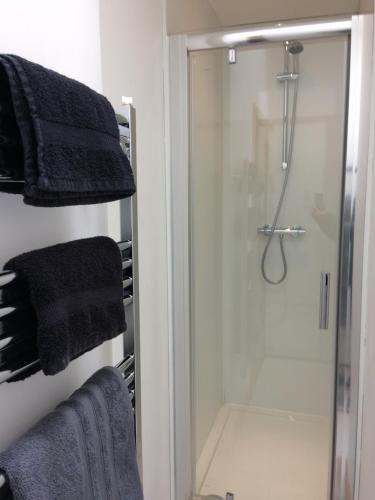 a bathroom with a shower with towels on a rack at Eastgate Apartment in Inverness