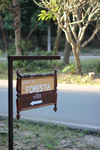 a sign in the grass next to a street at Foresta Villa in Hang Dong