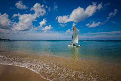 a small sail boat in the water on the beach at East Winds St. Lucia- All Inclusive in Gros Islet
