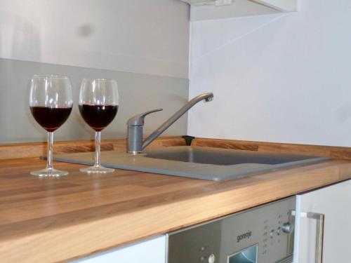 two glasses of red wine sitting on a kitchen counter at Strandläufer Kühlungsborn in Kühlungsborn