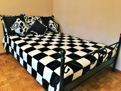 a black and white checkered bed in a bedroom at Apartment Wali in Soko Banja