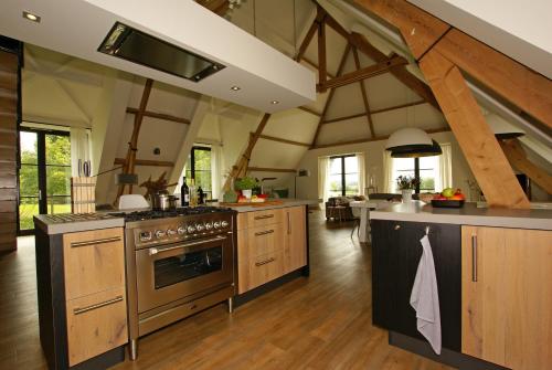 a large kitchen with wooden floors and wooden beams at Vakantiehuis Nijmegen in Erlekom