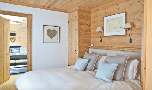 ein Schlafzimmer mit einem großen weißen Bett mit blauen Kissen in der Unterkunft Edelweiss in Chamonix-Mont-Blanc