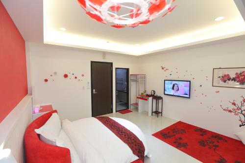 a bedroom with a bed and a red couch at 醇境民宿市區車庫停車場 in Hualien City