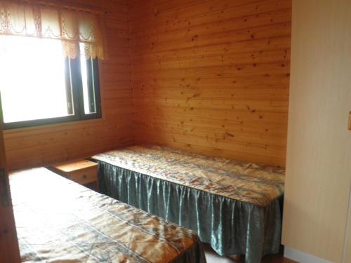 a room with two beds in a log cabin at Koskelon Lomamökit in Rääkkylä