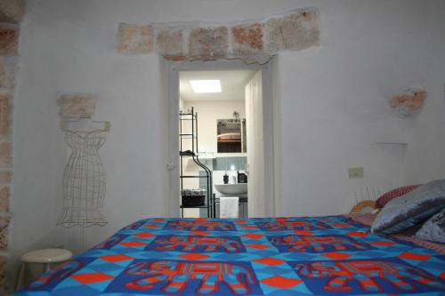 a bedroom with a bed with a colorful quilt on it at I Trulli Di Acquarossa in Cisternino