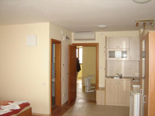 a kitchen with white cabinets and a sink in a room at Byala Palace Apartments in Byala