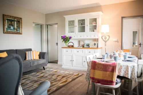 a living room with a table and a couch at Rose Meadow Cottage in Liscannor