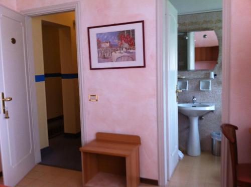 uma casa de banho com um lavatório e uma parede rosa em Hotel La Palma em Lido di Camaiore