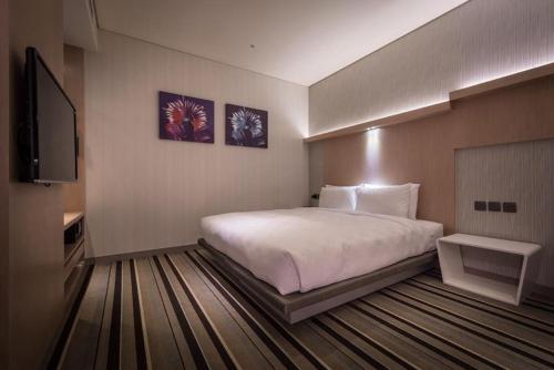 a hotel room with a bed and a flat screen tv at Taipei 101 SPARKLE Hotel in Taipei