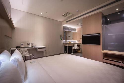 a hotel room with a large bed and a kitchen at Taipei 101 SPARKLE Hotel in Taipei