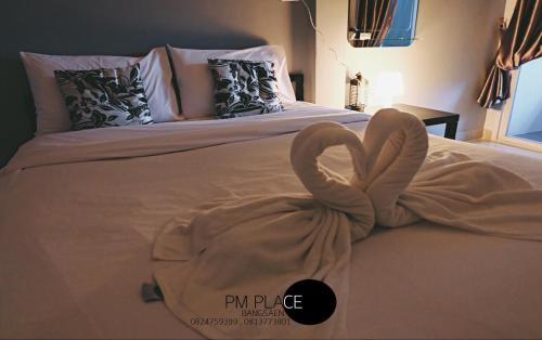 een bed met een handdoek in de vorm van een hart bij PM Place in Bangsaen