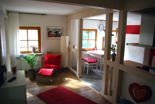 sala de estar con silla roja y mesa en Waldblick, en Bleckede