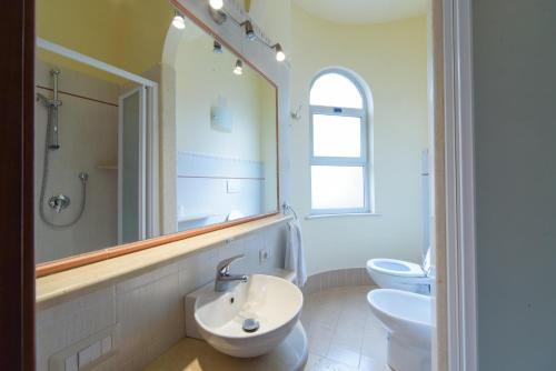 a bathroom with two sinks and a mirror and two toilets at San Giacomo in SantʼAlessio Siculo