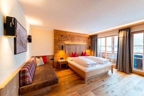 a bedroom with a bed and a couch in it at Alpengasthof Rossmoos in Alpbach