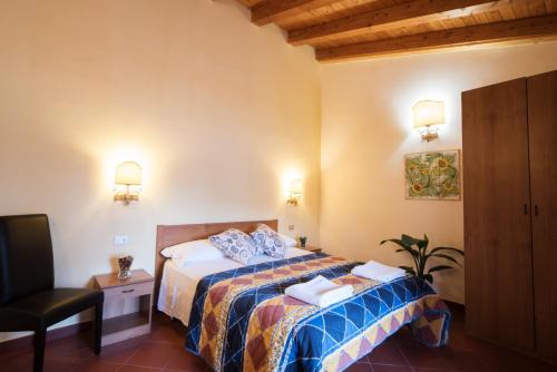 a hotel room with a bed and a chair at San Giacomo in SantʼAlessio Siculo