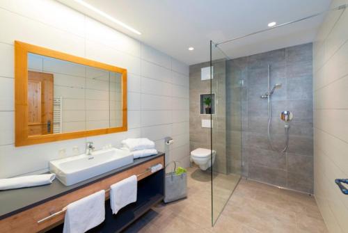 a bathroom with a sink and a glass shower at Alpengasthof Rossmoos in Alpbach