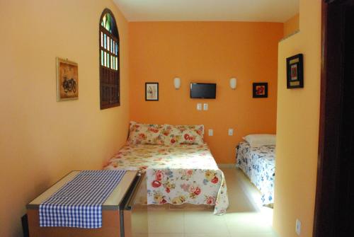 a bedroom with two beds and a window at Hotel Rusticos in Conceição da Barra