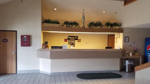 a waiting room with a counter and potted plants at Syracuse Inn and Suites in Syracuse