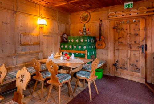 a dining room with a table and chairs and a guitar at Alpengasthof Rossmoos in Alpbach