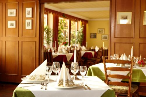 a dining room with tables with green tablecloths at Hotel Winzerverein in Zeltingen-Rachtig