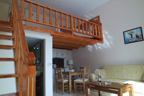 a living room with a staircase and a dining room at Relax Apts Saranda in Sarandë